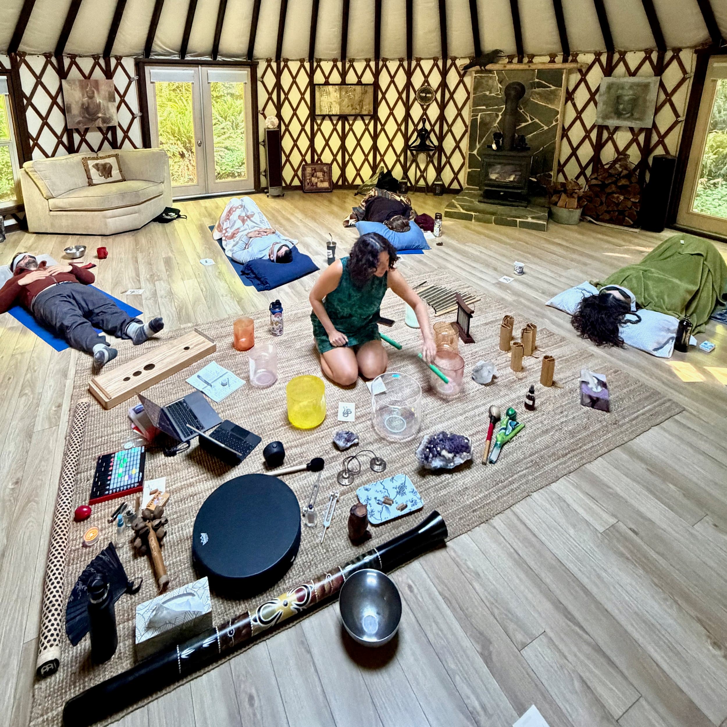 Crystal singing bowls being played among drums, chimes and a didgeridoo.
